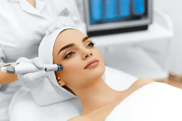 A woman receiving a Hydro Boost facial treatment at Kaya by Reema Salon, showcasing anti-aging and organic peel services.