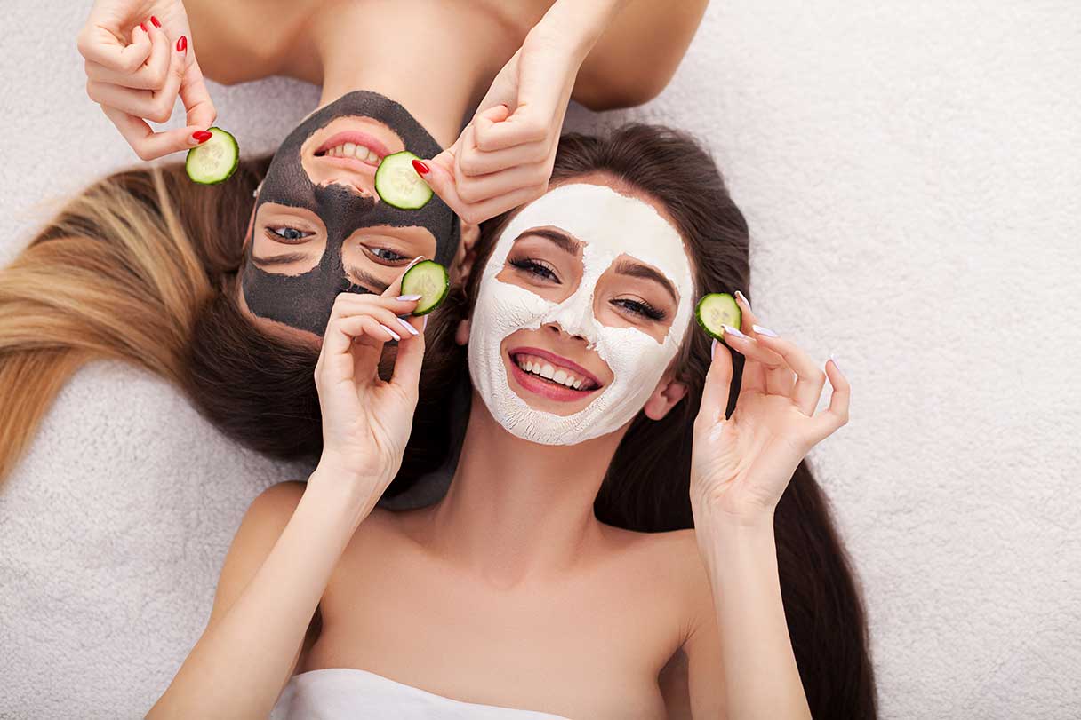 Two women wearing facial masks, enjoying a rejuvenating treatment at Kaya by Reema Salon, highlighting skincare services.