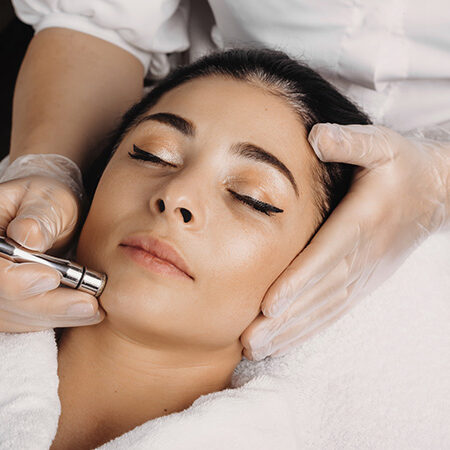 A woman receiving a Hydro Boost facial treatment at Kaya by Reema Salon, showcasing anti-aging and organic peel services.